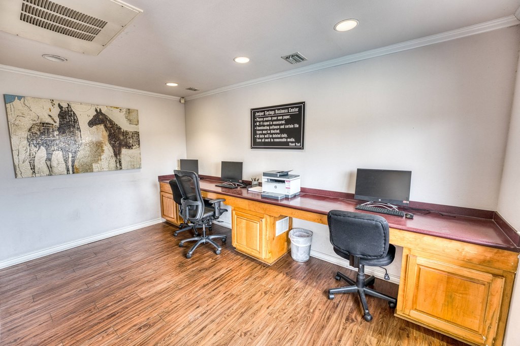 a room with two desks and two chairs and a painting on the wall at Juniper Springs Apartments, Austin, TX